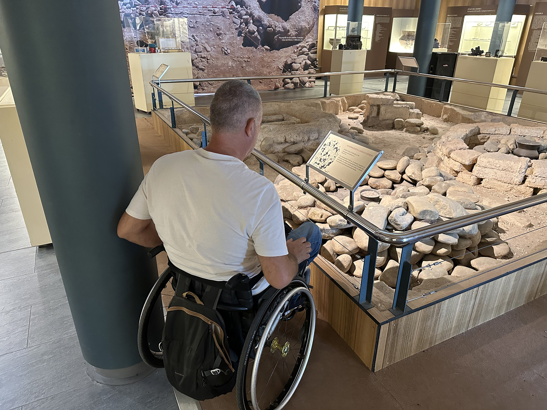 Hombre usuario de silla de ruedas admirando una maqueta de una estación ferroviaria en el Museo de Castejón.